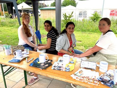 Auszubildende und Gäste am CKQ-Stand, wo sie sich Henna-Tattoos anfertigen lassen