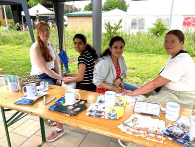 Auszubildende und Gäste am CKQ-Stand, wo sie sich Henna-Tattoos anfertigen lassen